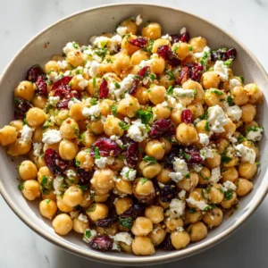 A bright, overhead shot of the healthy chickpea salad with feta and cranberry in a serving bowl, showcasing the fresh parsley and creamy texture.