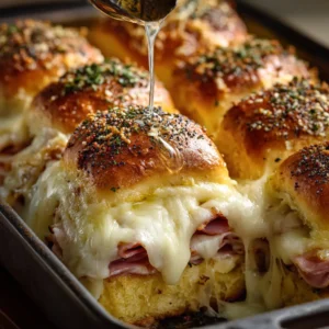 Ham and Cheese Sliders: The Only Recipe You Need 4 A close-up shot of a baked ham and cheese slider showing the layers of melted Swiss cheese and savory deli ham inside a soft Hawaiian roll.