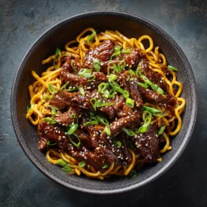 Sticky Garlic Beef (The Easiest, Most Flavorful Recipe!) 3 A close-up shot of a bowl of tender sticky garlic beef stir fry, showing the glossy sauce and perfectly cooked beef slices.