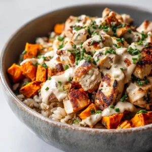 Chicken and Sweet Potato Rice Bowl: Your New Weeknight Favorite 4 A close-up shot of a healthy chicken and sweet potato rice bowl in a white bowl, highlighting the vibrant colors of the roasted sweet potatoes, corn, and fresh cilantro.