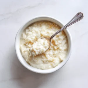 An overhead shot of a bowl of homemade coconut rice pudding. The texture is visibly rich and creamy, showcasing the delicious result of the recipe.