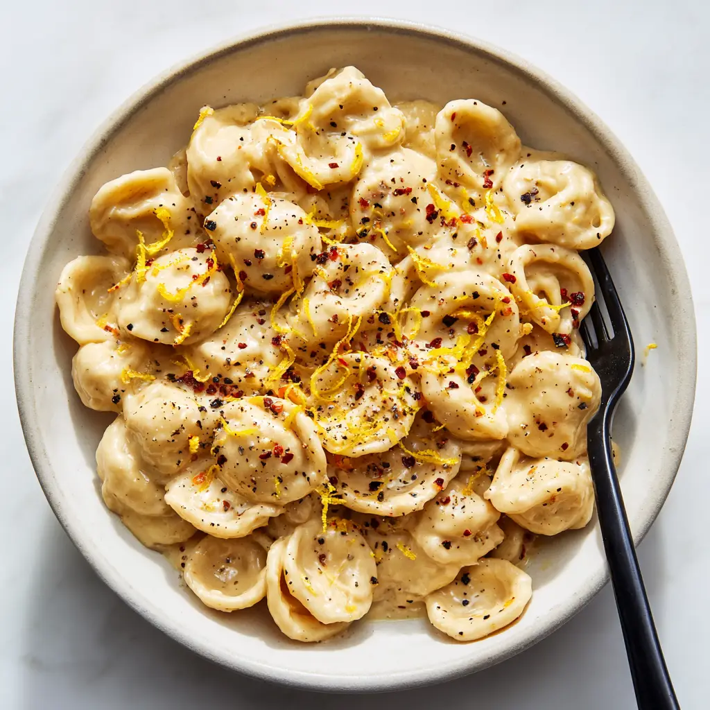 Creamy Roast Garlic and Lemon Pasta with Orecchiette 1 Top-down view of Creamy Roast Garlic and Lemon Pasta with visible strands of lemon zest and red chili flakes.
