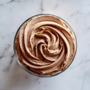 Chocolate Mousse Filling: The Ultimate Stabilized Recipe for Cakes and Pastries 3 Overhead view of Chocolate Mousse Filling in a glass bowl on a marble surface.